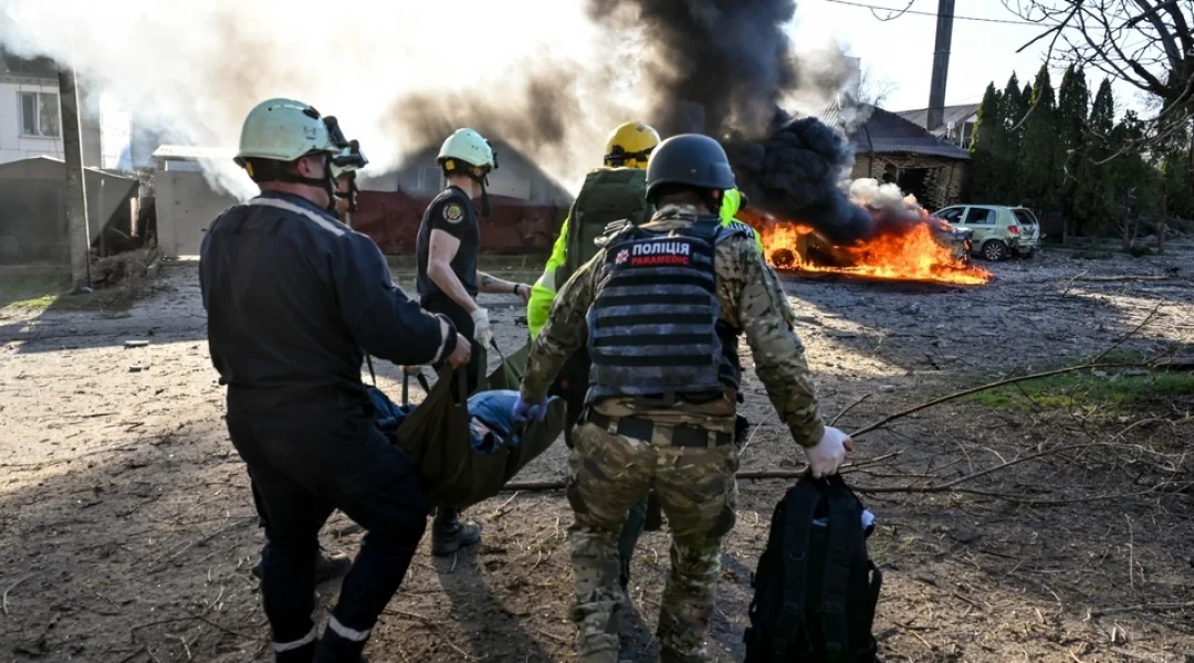 Рятувальники несуть пораненого на ношах після атаки КАБами на Харків
