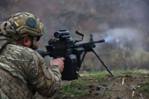 Український військовий веде вогонь з кулемета на позиції