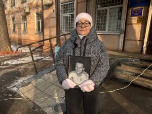 Жінка тримає портрет загиблого після ТЦК чоловіка біля районного суду в Кременчуці
