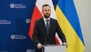 Міністр оборони Польщі Владислав Косіняк-Камиш на тлі прапорів Польщі та України