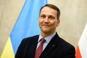 Міністр закордонних справ Польщі Радослав Сікорський на тлі прапорів України та Польщі
