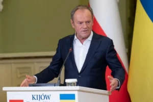 Дональд Туск на трибуні з прапорами Польщі та України щодо допомоги Києву