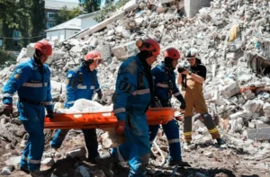 Рятувальники несуть постраждалого на ношах серед руїн після атаки РФ у Києві