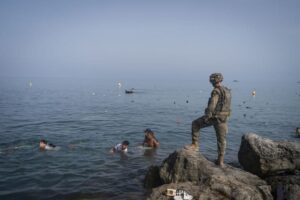 Іспанський військовий на скелях спостерігає за людьми у морі