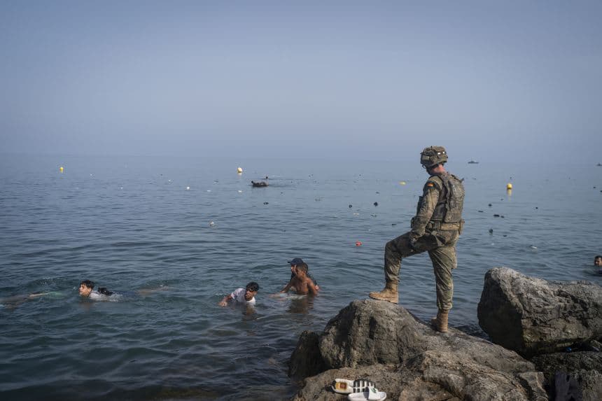 Іспанський військовий на скелях спостерігає за людьми у морі
